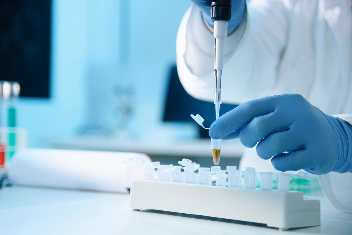 Scientist using a pipette to transfer liquid into a reaction tube